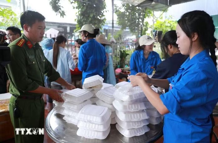 Công an xã cùng đoàn viên thanh niên cũng hỗ trợ bà con Bản Phúc Khoa đóng những suất cơm nóng hổi đưa đến cho bà con nhân dân xã Mường Than và các lực lượng. (Ảnh: Quý Trung/TTXVN)