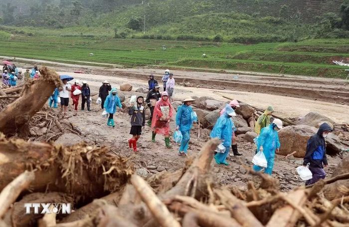 Người dân xã Than Uyên đưa những suất cơm nóng hổi ấm áp tình người cùng nhu yếu phẩm cần thiết đến với nhân dân Bản Chít và các lực lượng giúp dân khắc phục hậu quả do lũ dữ gây ra tại Mường Than. (Ảnh: Quý Trung/TTXVN)