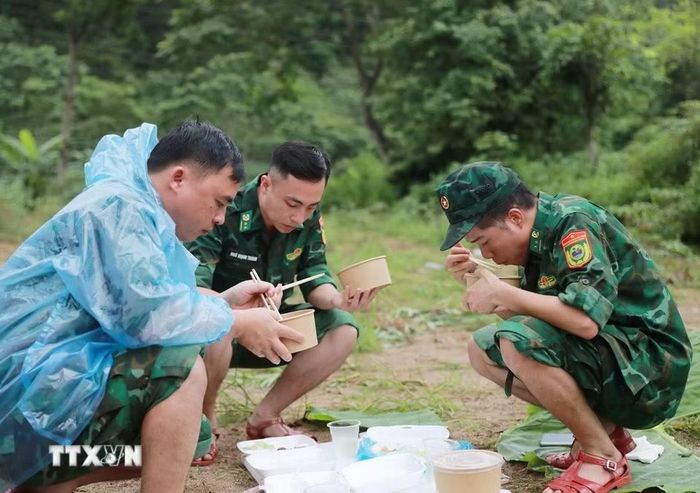 Bữa cơm trưa vội vã của các lực lượng giúp dân Bản Chít xã Mường Than khắc phục hậu quả thiên tai. (Ảnh: Quý Trung/TTXVN)