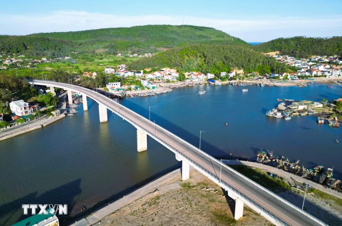 Khung cảnh hài hòa giữa cầu Lạch Quèn, những âu thuyền của ngư dân nơi cửa biển và dải núi Mành Sơn kỳ vĩ kết hợp với nét uốn lượn của luồng tuyến ra, vào lạch, tạo nên vẻ đẹp cuốn hút, thơ mộng. (Ảnh: Xuân Tiến/TTXVN)