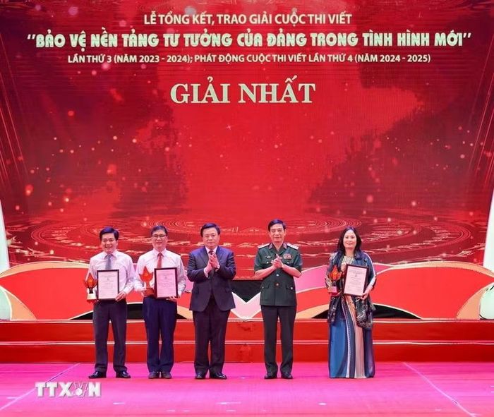 Đại tướng Phan Văn Giang, Ủy viên Bộ Chính trị, Bộ trưởng Bộ Quốc phòng và ông Nguyễn Xuân Thắng, Ủy viên Bộ Chính trị, Chủ tịch Hội đồng Lý luận Trung ương, Giám đốc Học viện Chính trị Quốc gia Hồ Chí Minh trao giải cho các tác giả, nhóm tác giả đoạt giải Nhất cuộc thi viết " Bảo vệ nền tảng tư tưởng của Đảng trong tình hình mới." (Ảnh: Thanh Tùng/TTXVN)
