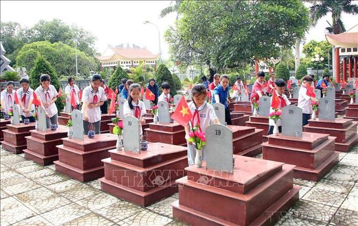Thiếu nhi và đoàn viên thanh niên Sơn La thắp hương tưởng nhớ các Anh hùng liệt sĩ tại Nghĩa trang liệt sĩ Yên Châu. Ảnh: Quang Quyết/TTXVN