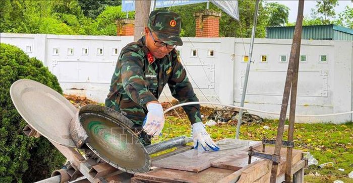 Trung tá Nguyễn Văn Ngọc với chiếc máy mòi đá. Ảnh: TTXVN phát