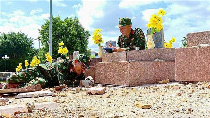 Trung tá Nguyễn Văn Ngọc (trái) trực tiếp đo kích thước từng phần mộ để phục vụ công tác hoàn nguyên. Ảnh: TTXVN phát