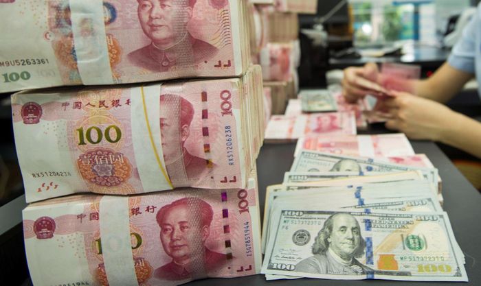Đồng nhân dân tệ của Trung Quốc và đồng đô la Mỹ. Ảnh: AFP/TTXVN (Không được phép chia sẻ, khai thác bởi bên thứ ba).