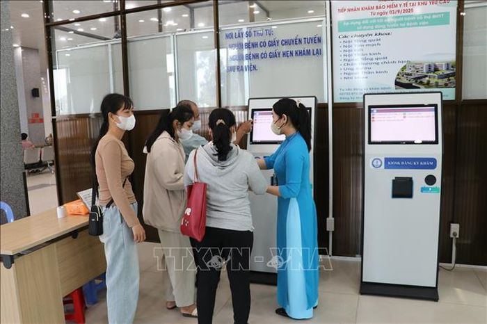 Nhân viên Bệnh viện Đa khoa Tiền Giang, tỉnh Đồng Tháp, hướng dẫn người bệnh làm thủ tục đăng ký khám bệnh trực tuyến.