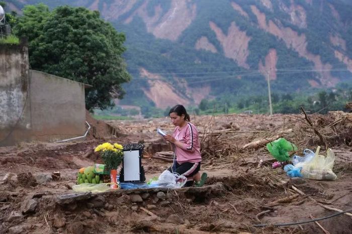 Chị Nga mong sớm tìm được mẹ sau cơn lũ. Ảnh: Nguyễn Mạnh.