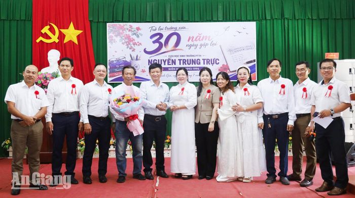 Thầy Nguyễn Thanh Tùng, Hiệu trưởng Trường THPT Nguyễn Trung Trực 1 (thứ năm, từ trái qua) tặng hoa chúc mừng Ban Liên lạc cựu học sinh Trường THPT Nguyễn Trung Trực niên khóa 1993 - 1996.