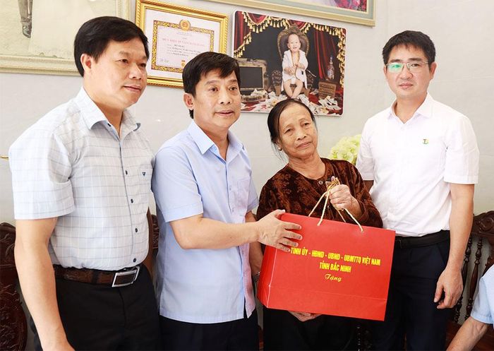 Đồng chí Nguyễn Anh Tuấn tặng quà bà Đỗ Thị Ký - vợ liệt sĩ Tạ Quang Giáp.