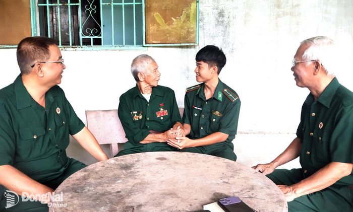 Anh hùng Lực lượng vũ trang nhân dân Dương Đức Thùng (thứ 2, từ trái qua) trò chuyện với thế hệ trẻ và các cựu chiến binh.