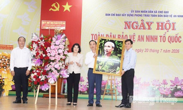 Lãnh đạo tỉnh tặng bức tranh Bác Hồ và hoa cho xã Chợ Gạo.