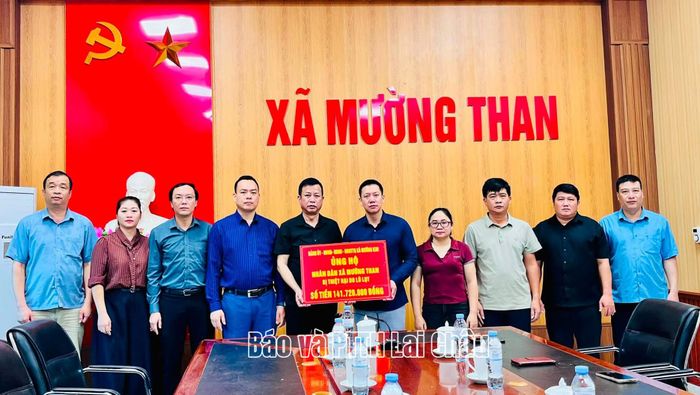 Đoàn công tác xã Mường Kim trao tiền hỗ trợ cho xã Mường Than khắc phục hậu quả thiên tai.