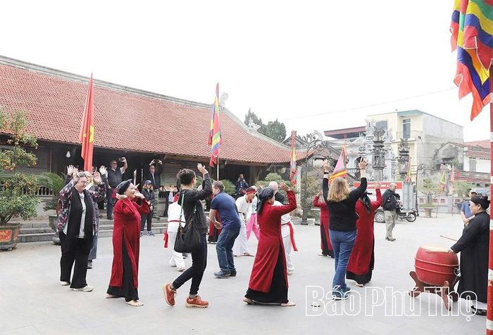 Du khách và các nghệ nhân, người dân làng Hùng Lô, phường Vân Phú giao lưu, trải nghiệm hát Xoan tại đình làng.