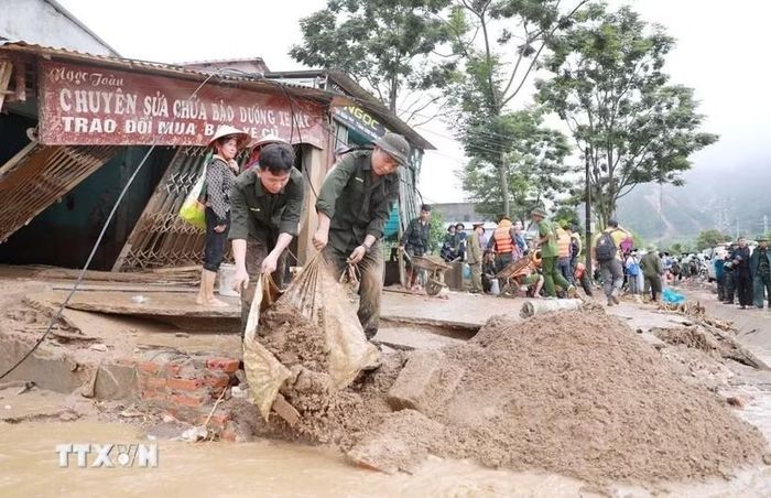  Lực lượng Công an hỗ trợ người dân Bản Chít nơi xảy ra lũ quét xã Mường Than, tỉnh Lai Châu khắc phục hậu quả. Ảnh: TTXVN. 