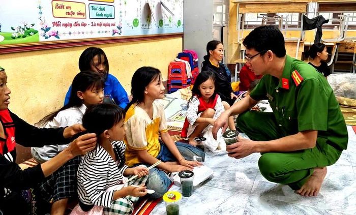 Công an trao tận tay suất cơm nóng đến các em nhỏ ở nơi tránh trú lũ quét. Ảnh: CTV