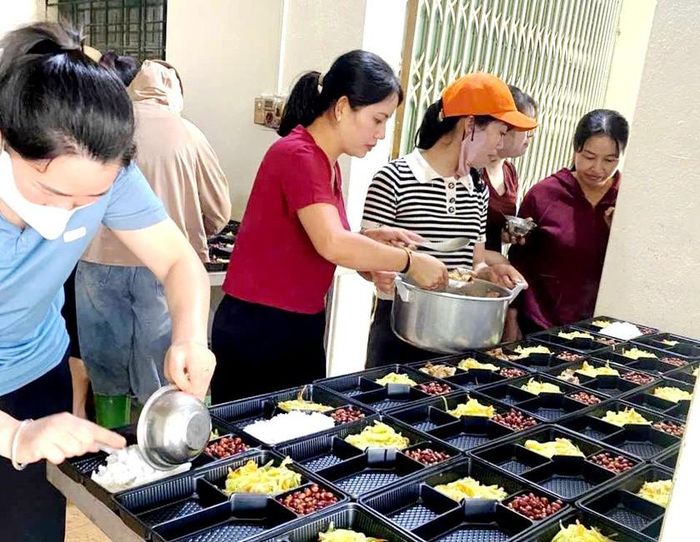 Đảng ủy, UBND xã Than Uyên cùng tập thể cán bộ quản lý, giáo viên, nhân viên Trường Mầm non Mường Than chuẩn bị và trao 150 suất cơm miễn phí cho người dân bị ảnh hưởng bởi lũ quét và lực lượng đang làm nhiệm vụ cứu hộ, cứu nạn. Ảnh: CTV