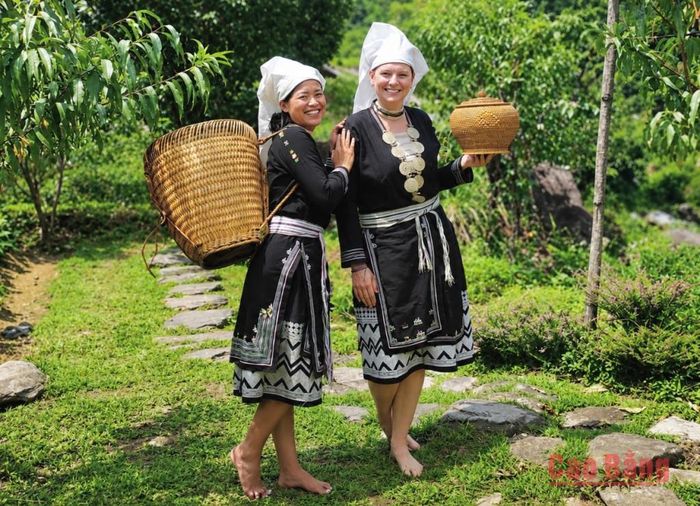 Du khách nước ngoài trải nghiệm không gian văn hóa và trang phục truyền thống của người Dao Tiền trong hành trình khám phá tuyến du lịch phía Tây.
