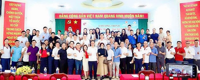  Đoàn về nguồn chụp hình lưu niệm với địa phương