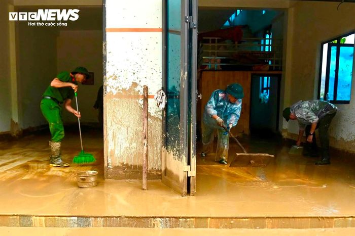 Người cầm xẻng, người cầm chổi, người hợp sức đẩy từng tấm ván, khẩn trương dọn lớp bùn đất dày đặc phủ kín nền nhà.