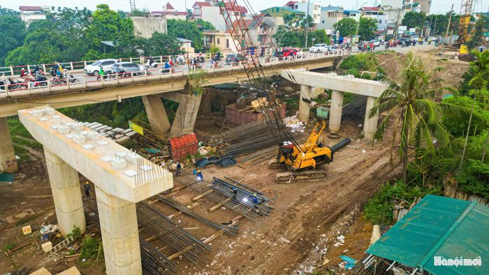 Ghi nhận tại công trường, nhiều trụ cầu nằm giữa sông Đáy đã hoàn thành phần bê tông. Công nhân và máy móc tiếp tục gia công cốt thép, lắp dựng cốp pha để chuẩn bị thi công các hạng mục tiếp theo.