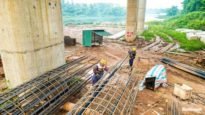 Công nhân thi công dầm thép phục vụ xây dựng móng và trụ cầu.