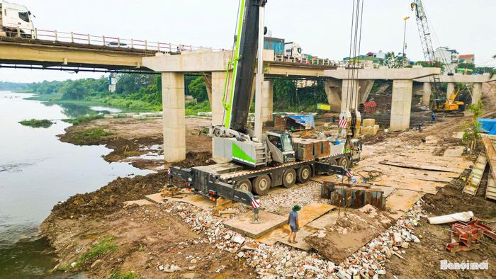 Máy móc, cần cẩu chuyên dụng được huy động thi công các hạng mục cầu vượt sông Đáy.