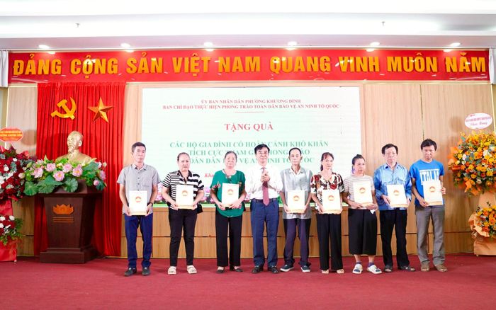 Bí thư Đảng ủy, Chủ tịch HĐND phường Khương Đình Võ Đăng Dũng trao quà cho các gia đình có hoàn cảnh khó khăn tích cực tham gia phong trào toàn dân bảo vệ an ninh Tổ quốc. Ảnh: Hồng Thái