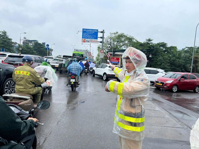 Cảnh sát giao thông điều tiết giao thông trên cầu mùa mưa bão. Ảnh: Ngân Hạ