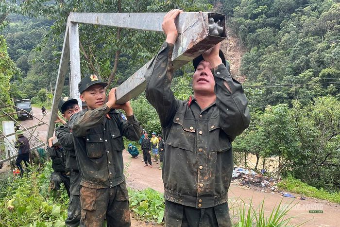 Vận chuyển khung sắt để sửa chữa công trình bị hư hỏng sau mưa lũ. Ảnh: Nguyễn Hằng