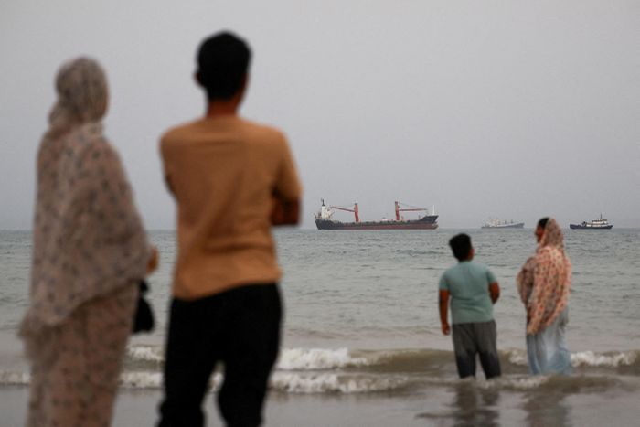 Người dân Iran đứng trên bờ biển trông ra eo biển Hormuz. Ảnh: Reuters.