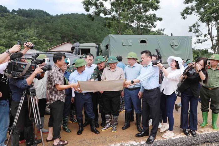 Lãnh đạo tỉnh Lai Châu báo cáo với Phó Thủ tướng Chính phủ Hồ Quốc Dũng về khu vực bắt đầu xảy ra lũ quét. Ảnh: Quý Trung – TTXVN