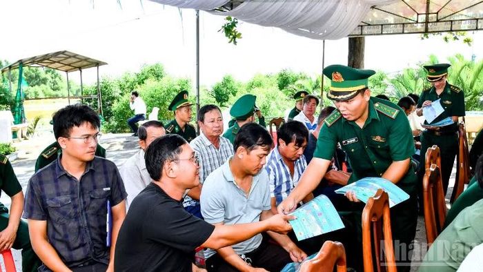Cán Bộ đồn Biên phòng Trung Bình cấp phát tờ rơi tuyên truyền chống khai thác IUU cho bà con ngư dân tham dự lễ ra quân.