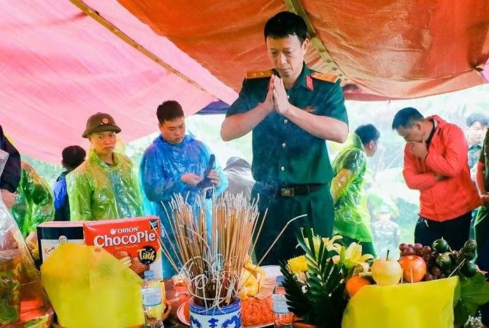 Trước lúc lực lượng chức năng thực hiện cất bốc 2 hài cốt liệt sĩ, Trung tá Nguyễn Ngọc Toan đã đứng thật lâu trước 2 phần mộ.