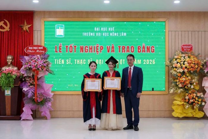 GS. TS Trần Đăng Hòa - Phó Giám đốc ĐH Huế trao Giấy khen của Giám đốc ĐH Huế cho Trần Thị Huyền (ở giữa) vì đạt kết quả học tập và rèn luyện Xuất sắc trong toàn khóa học, năm 2026.
