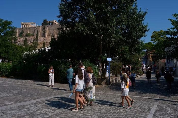 Du khách đi bộ gần Acropolis ở Athens, Hy Lạp, ngày 21/7/2026, sau vụ hai khách du lịch bị đâm dao trên phố đi bộ gần lối vào khu di tích khảo cổ. Ảnh: AP/Petros Giannakouris.