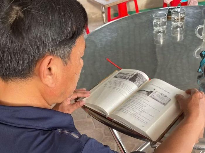 Gia đình liệt sĩ Nguyễn Xuân Hương bên cuốn sách viết về cha mình.