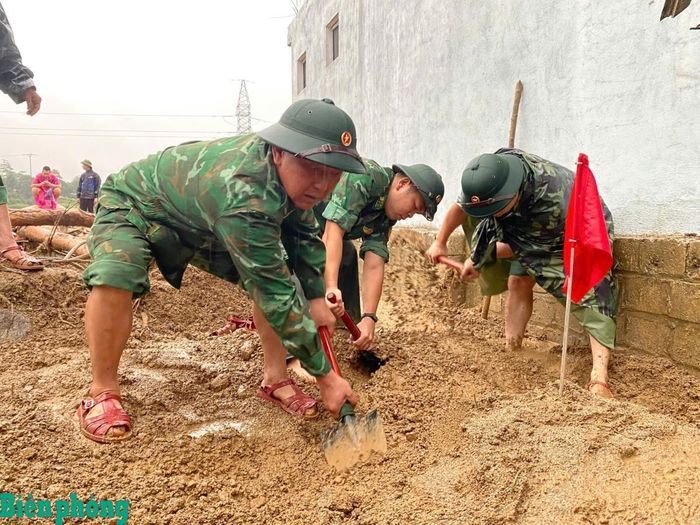 Cán bộ, chiến sĩ Bộ đội Biên phòng đào tìm tại vị trí nghi có nạn nhân bị vùi lấp, được đánh dấu trong quá trình chó nghiệp vụ rà soát hiện trường. Ảnh: Văn Hợi