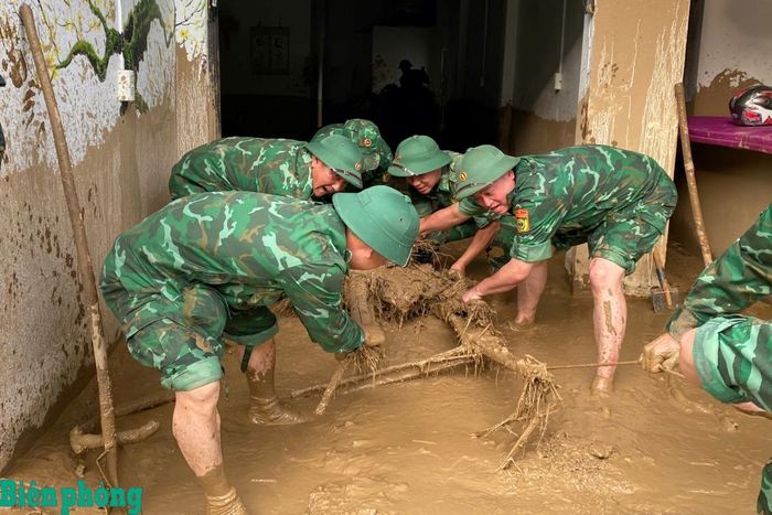 Cán bộ, chiến sĩ Bộ đội Biên phòng phối hợp dọn bùn đất, cây gỗ và vật cản trong nhà dân, góp phần giúp các gia đình sớm ổn định cuộc sống. Ảnh: Đức Duẩn