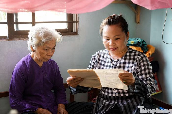 Chị Nguyễn Thanh Thủy, (con nuôi bà Nguyễn Thị Lệ), xúc động khi đọc lại những lá thư, tờ đơn của mẹ liệt sĩ Huỳnh Văn Quên gửi cơ quan chức năng đề nghị công nhận bà Lệ là con dâu họ Huỳnh. Ảnh: Nguyễn Tiến.