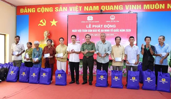 Đại tá Lê Văn Quý và ông Lâm Thành Sĩ, Bí thư Đảng ủy xã Tri Tôn trao quà cho người dân có hoàn cảnh khó khăn
