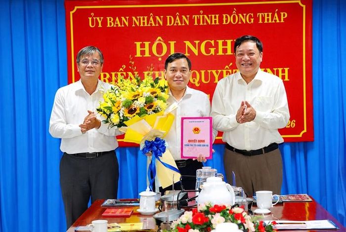 Chủ tịch UBND tỉnh Đồng Tháp Phạm Thành Ngại trao Quyết định bổ nhiệm và Phó Trưởng Ban Tổ chức Tỉnh ủy Đỗ Quốc Chương tặng hoa chúc mừng đồng chí Ngô Huỳnh Quang Thái. (Ảnh: dongthap.gov.vn)