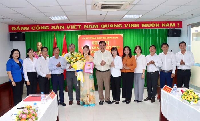 Chủ tịch UBND tỉnh Đồng Tháp Phạm Thành Ngại (thứ 7 từ phải sang) trao Quyết định và tặng hoa chúc mừng đồng chí Phạm Thị Ngọc Đào. (Ảnh: dongthap.gov.vn)