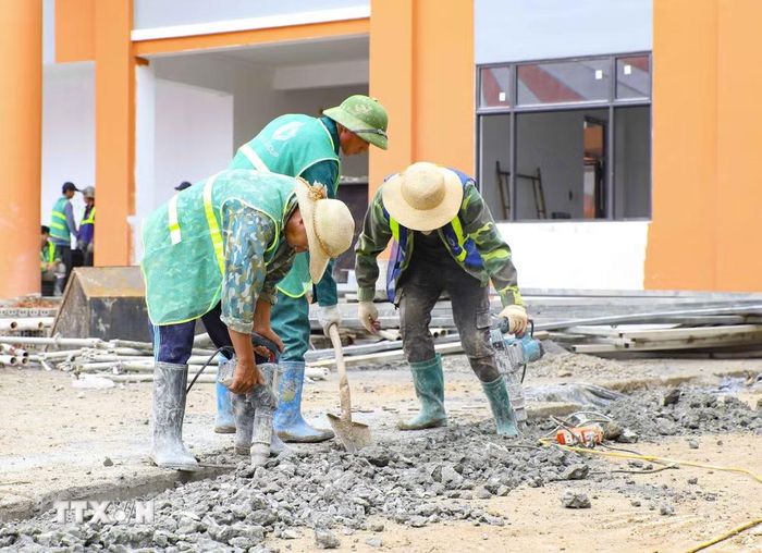 Công nhân thi công nền sân, hoàn thiện khuôn viên Trường Phổ thông nội trú liên cấp Tiểu học và Trung học cơ sở xã Thanh Nưa. (Ảnh: Xuân Tư/TTXVN)