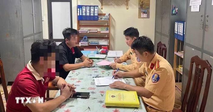 Hai tài xế xe khách làm việc với cảnh sát giao thông (Công an tỉnh Tuyên Quang). (Ảnh: TTXVN phát)