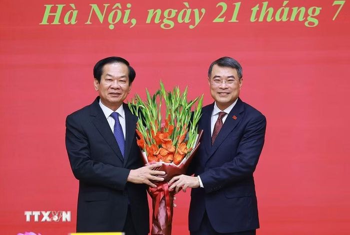 Thủ tướng Lê Minh Hưng tặng hoa cảm ơn đồng chí Đỗ Thanh Bình, nguyên Bộ trưởng Bộ Nội vụ. (Ảnh: Dương Giang/TTXVN)