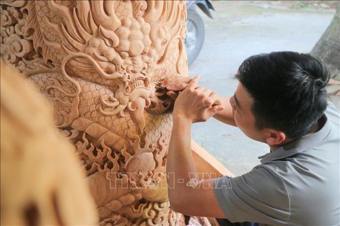 Người thợ tỉ mỉ khắc những hoa văn tinh xảo.