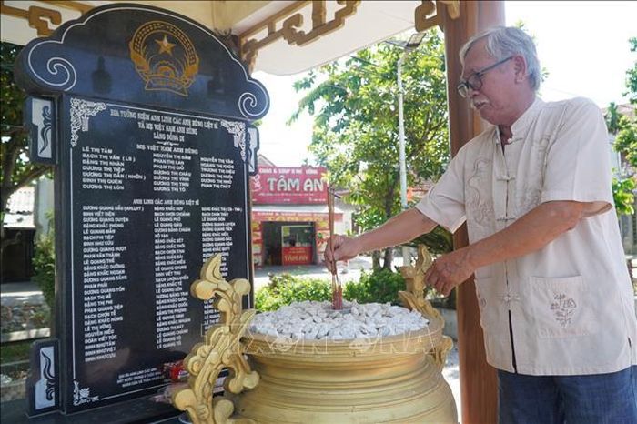 Ông Đặng Quốc Sim (làng Đồng Di, xã Phú Hồ) thắp hương tại Bia tưởng niệm ghi danh các Mẹ Việt Nam anh hùng và Anh hùng liệt sĩ của làng.