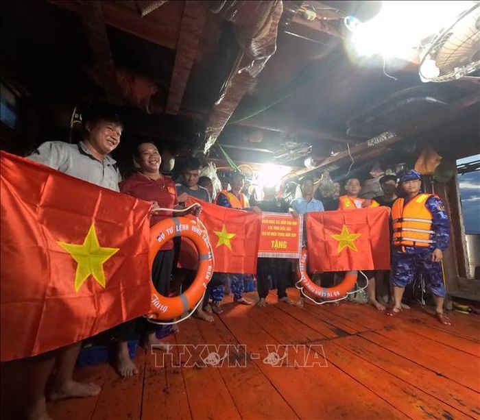 Cán bộ, chiến sĩ Bộ Tư lệnh Vùng Cảnh sát biển 2 trao cờ Tổ quốc và quà động viên ngư dân yên tâm vươn khơi, bám biển, chấp hành đúng các quy định trong khai thác thủy sản.