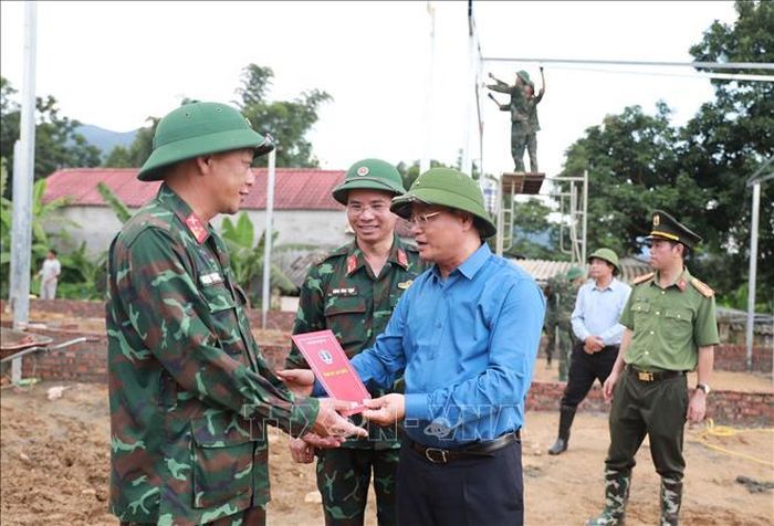 Bí thư Tỉnh ủy Lai Châu Lê Minh Ngân tặng quà động viên lực lượng Quân đội đang ngày đêm thi công xây dựng nhà cho các hộ dân. Ảnh: Quý Trung/TTXVN