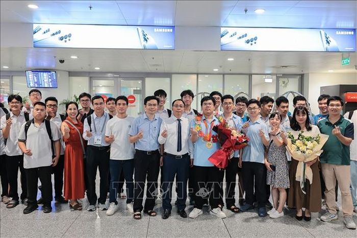 Ban lãnh đạo trường Trường Đại học Khoa học Tự nhiên (Đại học Quốc gia Hà Nội) cùng Ban giám hiệu Trường THPT chuyên Khoa học Tự nhiên (Trường Đại học KHTN - ĐHQG Hà Nội) cùng thầy cô, bạn bè và người thân chúc mừng Nguyễn Đình Tùng (lớp 12, Trường THPT chuyên Khoa học Tự nhiên, Trường ĐH Khoa học Tự nhiên, ĐHQG Hà Nội) đạt huy chương Vàng tại Kỳ thi Olympic Toán học Quốc tế (IMO) 2026. Ảnh: Lê Đông/TTXVN
